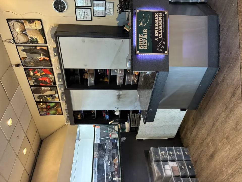 Inside Heel Quik — the workshop counter and ceiling shoe gallery at Suite 102